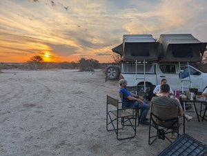 Menschen zelten auf einem Campingplatz in Botswana in der Natur. Sonnenuntergang