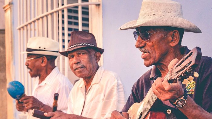 Drei Musiker auf einer Bank in Kuba